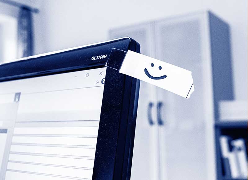 Ein motivierender Smiley Aufkleber an einem Monitor